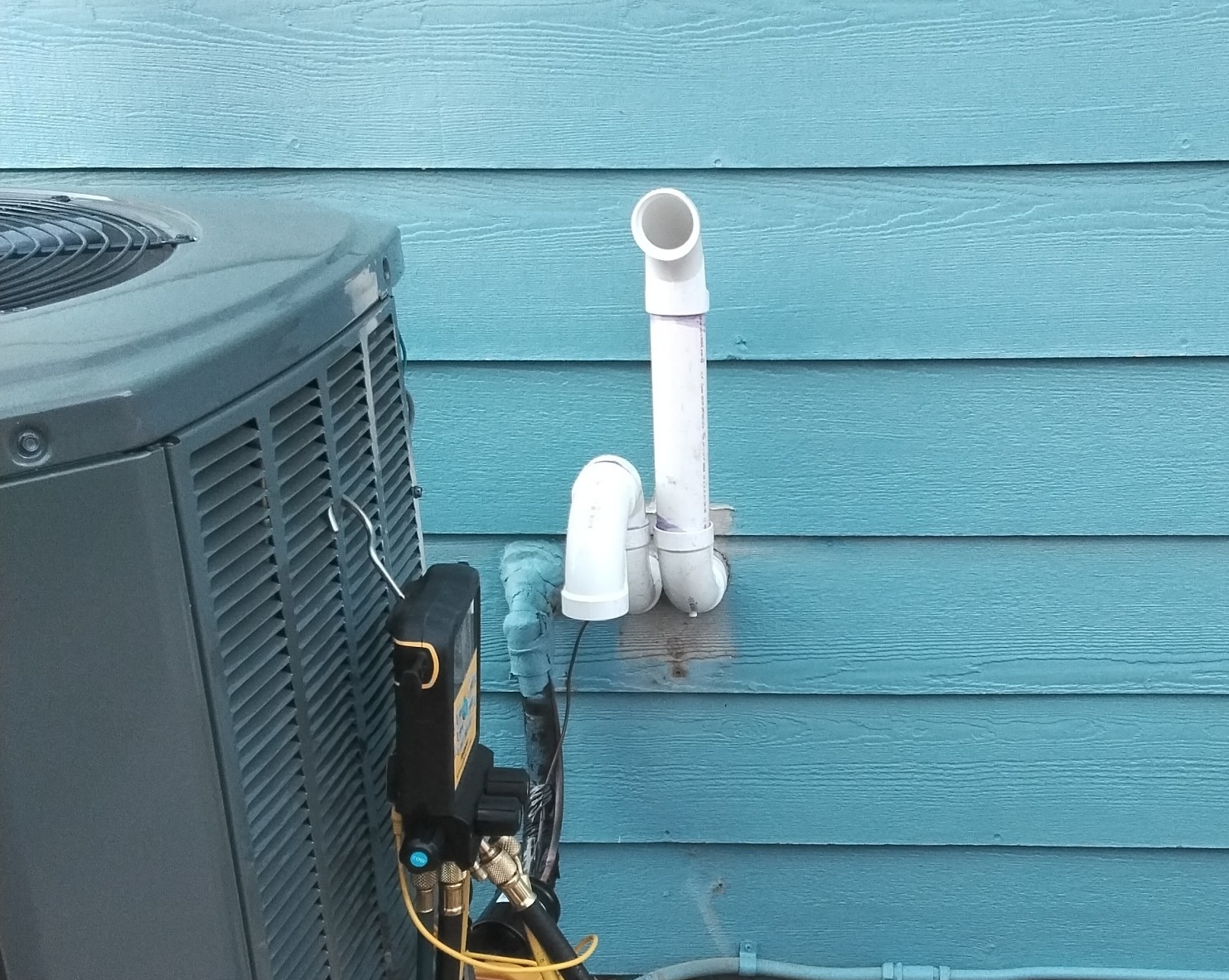 High-efficiency gas furnace's PVC vent pipes exiting a Colorado home