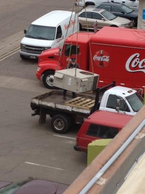 Old unit being craned to recycler’s truck.