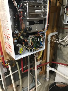 This tankless water heater is getting its annual service by KJ Thomas Mechanical